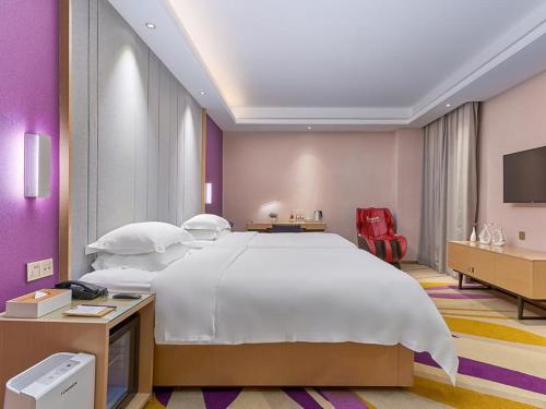 a large bedroom with a large bed and a tv at Lavande Hotel (Guangzhou North Railway Station Branch) in Huadu
