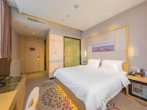 a bedroom with a large white bed and a television at Lavande Hotel Ningbo Railway Station Branch in Ningbo