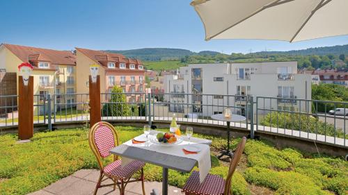 a patio with a table and chairs on a balcony at Hotel Villa Toskana in Leimen