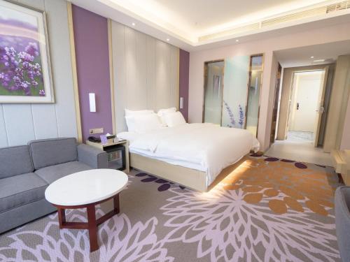 um quarto de hotel com uma cama e um sofá em Lavande Hotel(Macheng High-speed Station Branch) em Macheng