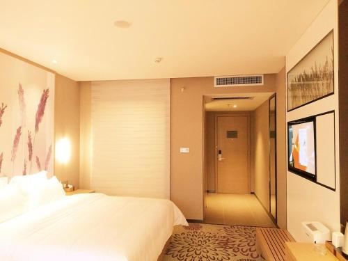 a bedroom with a large white bed and a hallway at Lavande Hotel Jinan Second Ring East Road Quanfu Overpass Branch in Jinan