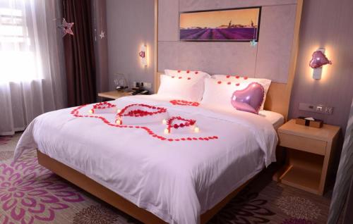 una habitación de hotel con una cama con un corazón dibujado en ella en Lavande Hotel Linyi People's Square Branch, en Linyi