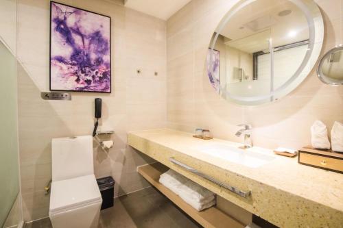 a bathroom with a sink and a mirror at Lavande Hotel (Liupanshui Ancient Town Branch) in Shuicheng