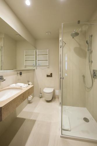 a bathroom with a shower and a toilet and a sink at Hotel Zalewski in Mrzeżyno