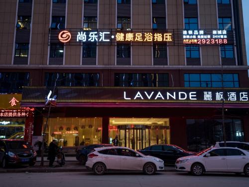 two white cars parked in front of a building at Lavande Hotel(Macheng High-speed Station Branch) in Macheng