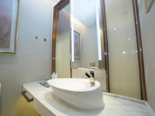 a bathroom with a white sink and a shower at Lavande Hotel (Guangzhou North Railway Station Branch) in Huadu