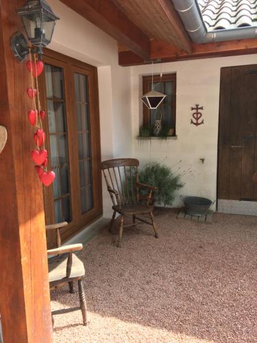 a porch with a rocking chair and a window at My little sweet home in Colombe