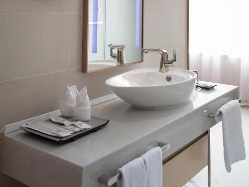 a bathroom with a white sink and a mirror at Lavande Hotel Yangchun Donghu in Yangjiang
