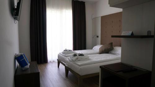 a living room with a white couch in front of a window at Park Hotel Val Di Monte ***S in Malcesine