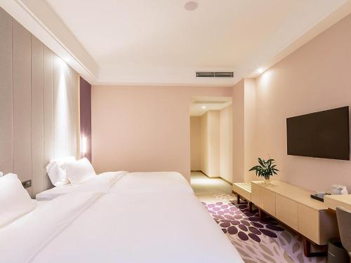 a hotel room with two beds and a flat screen tv at Lavande Hotel Changsha Xingsha Center in Xingsha