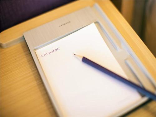a pen sitting on top of a notebook on a desk at Lavande Hotel (Nanchang West Railway Station Square Branch) in Nanchang