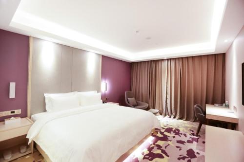 a bedroom with a large white bed and purple walls at Lavande Hotel (Jingdezhen Taoxichuan Creative Square Branch) in Jingdezhen