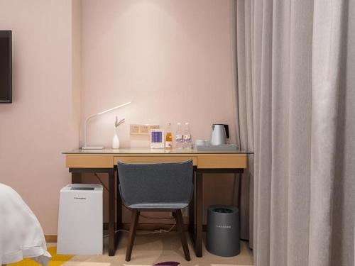 a desk with a chair in a room at Lavande Hotel (Guangzhou North Railway Station Branch) in Huadu
