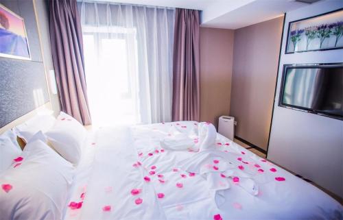 a bedroom with a white bed with flowers on it at Lavande Hotel Xiaogan Beijing Road Branch in Xiaogan