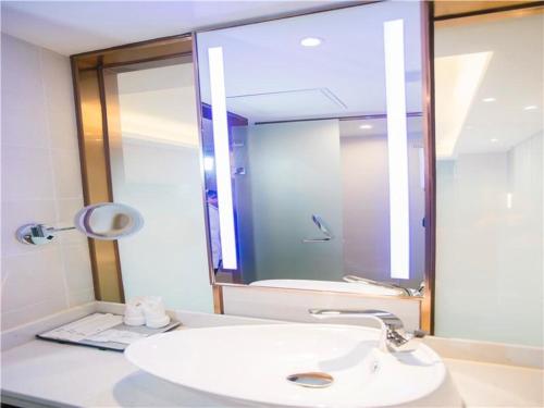 a bathroom with a white sink and a mirror at Lavande Hotel (Nanchang West Railway Station Square Branch) in Nanchang