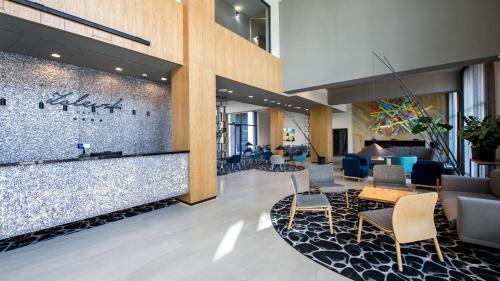 a lobby with a waiting area with chairs and tables at Hotel Zalewski in Mrzeżyno