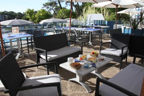 a group of chairs and tables with food on a patio at Hotel Mercedes in Hossegor