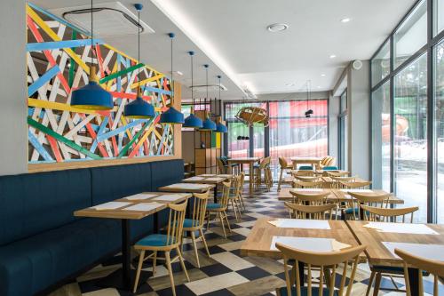a restaurant with tables and chairs and a colorful wall at Hotel Zalewski in Mrzeżyno