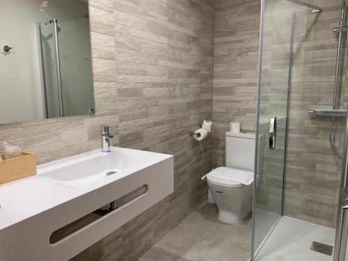 ein Bad mit einem Waschbecken, einem WC und einer Dusche in der Unterkunft Hotel El Cobertizo in Plasencia del Monte
