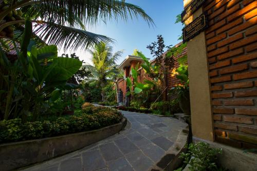 un passaggio attraverso un cortile con un edificio in mattoni di Ubud mesari Private Pool Villa ad Ubud