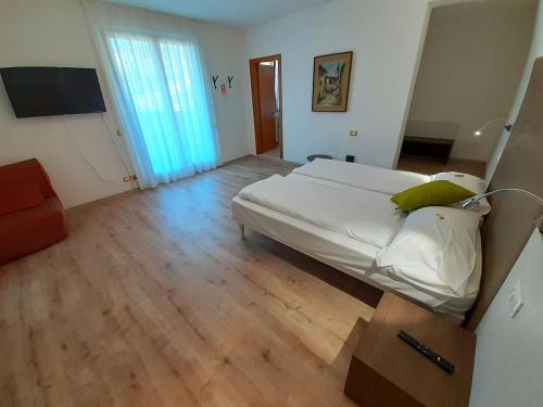 a bedroom with a large bed and a wooden floor at Park Hotel Val Di Monte ***S in Malcesine