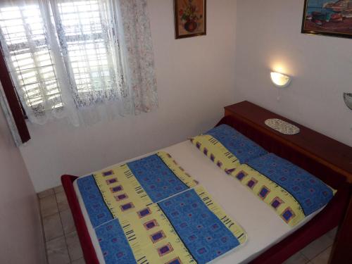 uma cama com duas almofadas num quarto em Queen's beach apartment Sabunike Nin - Green street II em Nin