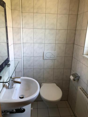 a bathroom with a white toilet and a sink at Ferienwohnungen Schäfer in Obersulm
