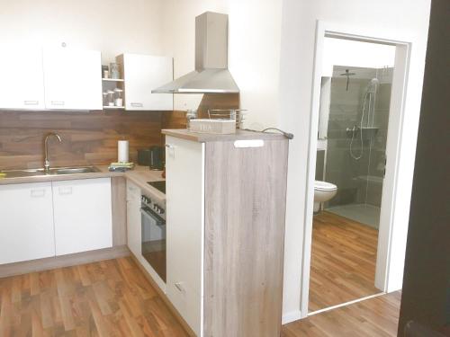uma cozinha com armários brancos, um lavatório e um fogão em Ferienwohnungen an der Obermaintherme em Bad Staffelstein