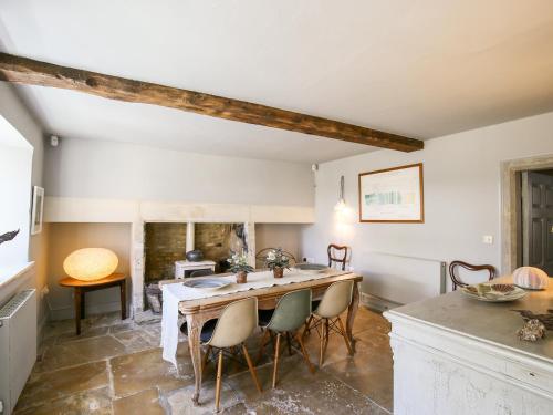 a kitchen with a table and chairs in a room at The Old Post Office in Cirencester