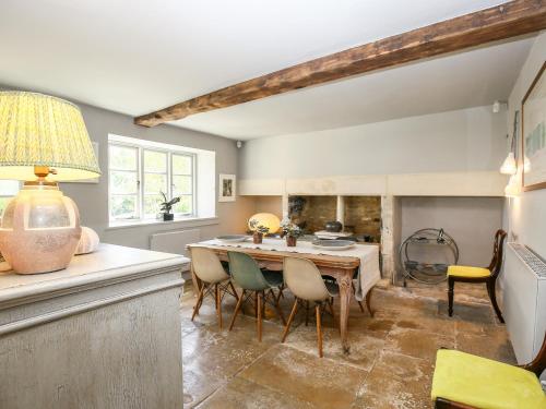 a dining room with a table and chairs at The Old Post Office in Cirencester