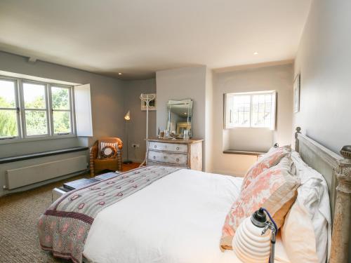 a bedroom with a large bed and a mirror at The Old Post Office in Cirencester