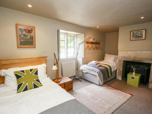 a bedroom with two beds and a fireplace at The Old Post Office in Cirencester