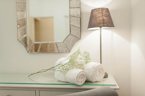 un miroir et une lampe sur une table en verre avec des serviettes dans l'établissement Sunlight Properties - Cristal - Old Town area, 3 Bedrooms, stunning Nice holiday rental apartment, à Nice