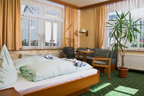クアオルト・オイビンにあるLand-gut-Hotel Cafe Meierのベッド、椅子、窓が備わるホテルルームです。
