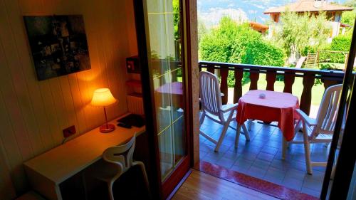a porch with a table and chairs on a balcony at Park Hotel Val Di Monte ***S in Malcesine