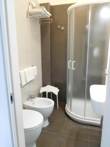 a bathroom with a shower and a toilet and a sink at Hotel Emperador in Lido di Jesolo