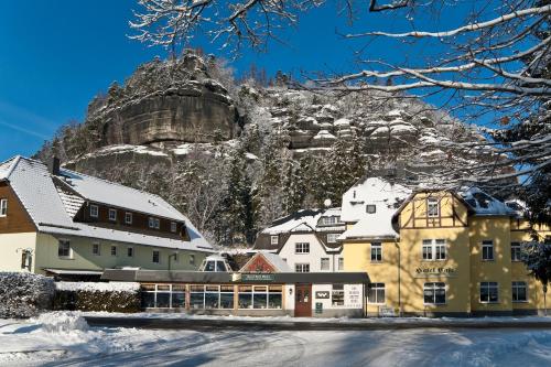 a town in the snow with a mountain in the background at Land-gut-Hotel Cafe Meier in Kurort Oybin
