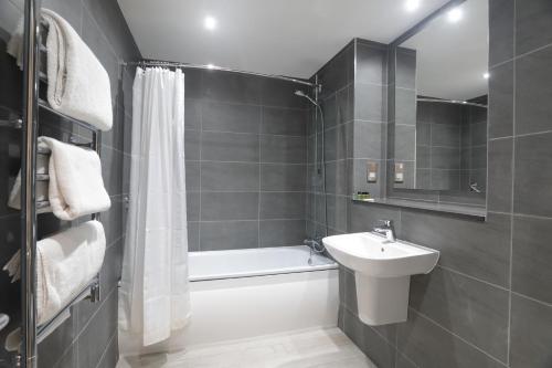 een badkamer met een wastafel, een bad en een toilet bij The Isles of Glencoe Hotel in Glencoe