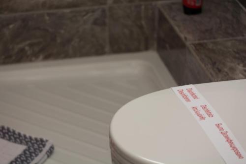 a white toilet with a sign on the side of it at Vila Aleka in Nei Poroi