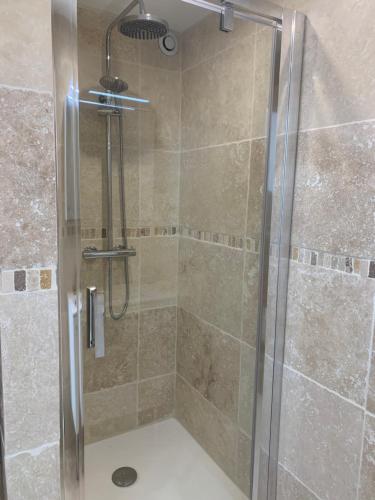 une douche avec une porte vitrée dans une salle de bain dans l'établissement La Venturonne Appartement neuf Rez de jardin 45 m2 vue mer et vignes 10 mn des plages, au Beausset