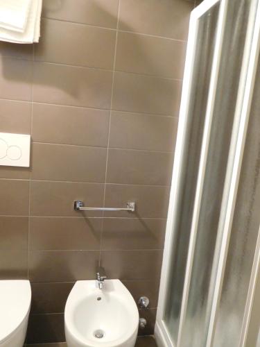 a small bathroom with a toilet and a sink at Hotel Emperador in Lido di Jesolo
