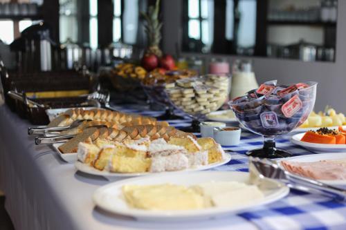 a table topped with plates of bread and other foods at Pousada Praia Do Meio in Torres