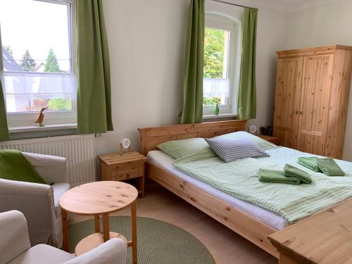 1 dormitorio pequeño con 1 cama y 1 silla en Gasthaus & Pension Zirkelstein en Schöna