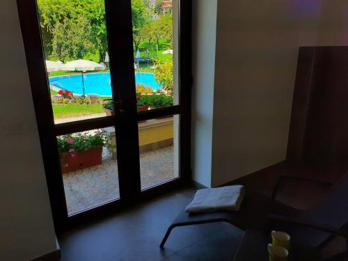 a room with a window looking out at a pool at Park Hotel Val Di Monte ***S in Malcesine