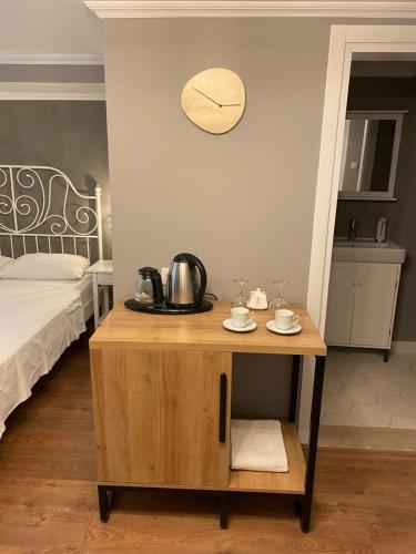 a small table in a room with a bed and a clock at Kinzi House in Canakkale