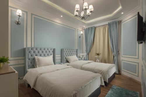 a bedroom with two beds and a chandelier at Miramar Boutique Hotel in Alexandria