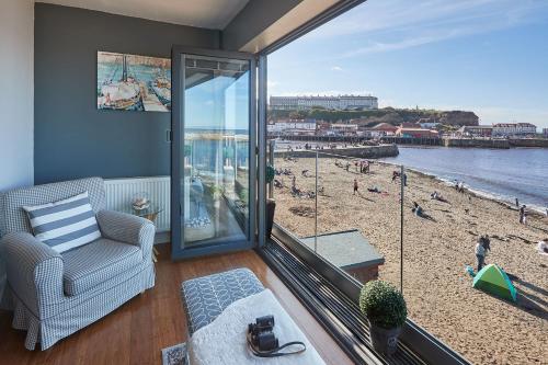 a living room with a view of a beach at Host & Stay - No 3 Sandside in Whitby