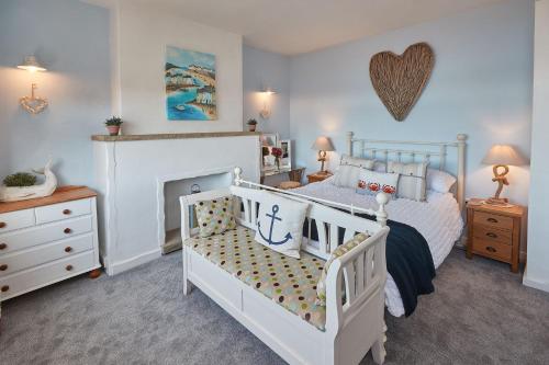 1 dormitorio con cama blanca y chimenea en Host & Stay - No 3 Sandside en Whitby