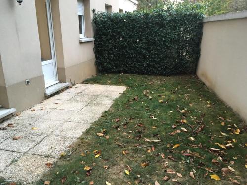 a yard with a hedge in front of a house at appartement proche de Disney et val d Europe in Chessy