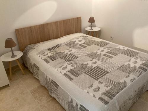 une chambre avec un lit avec une couette dessus dans l'établissement La Venturonne Appartement neuf Rez de jardin 45 m2 vue mer et vignes 10 mn des plages, au Beausset